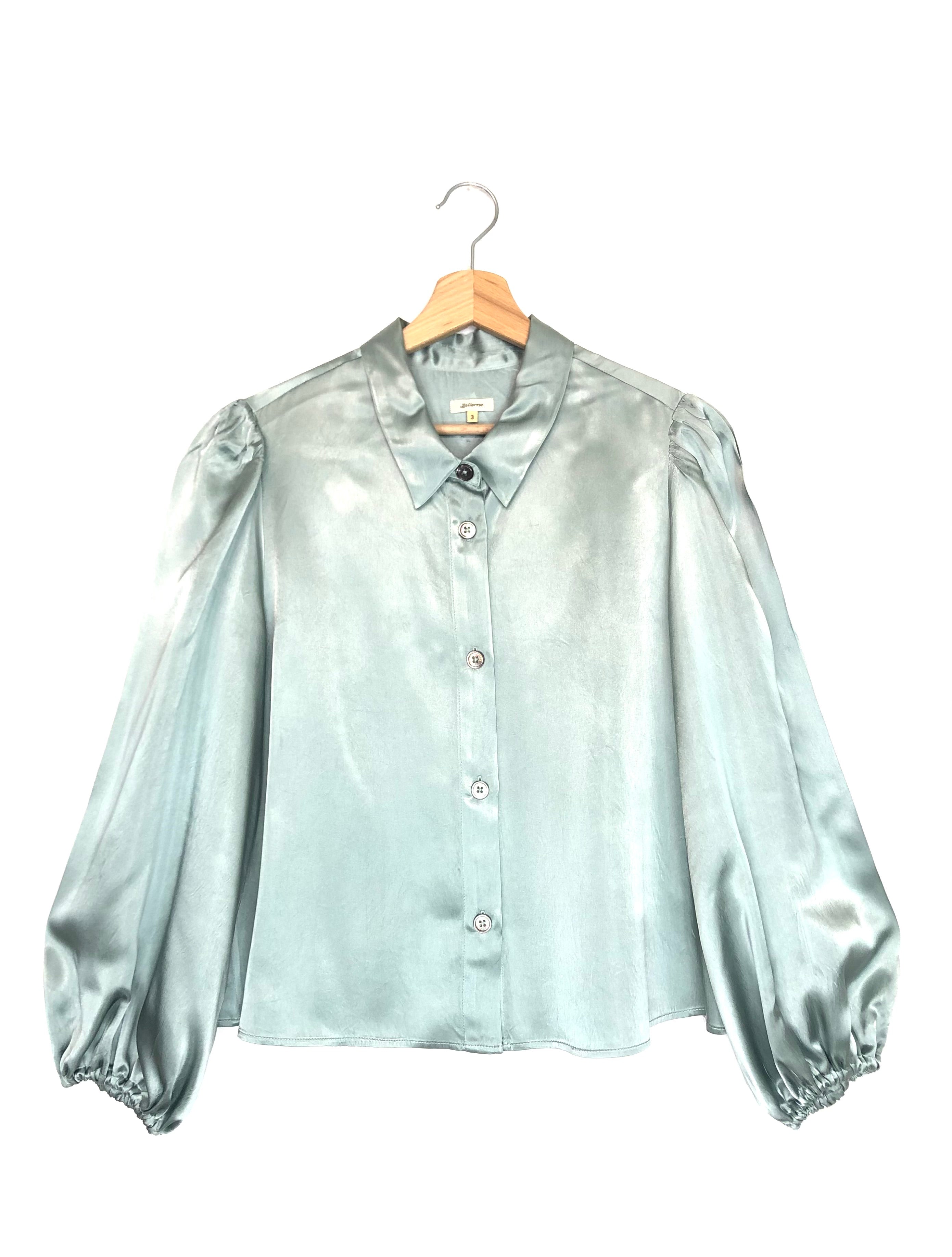 Rain-blue blouse on a hanger against a white background