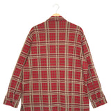Red and beige plaid shirt on a hanger against a white background