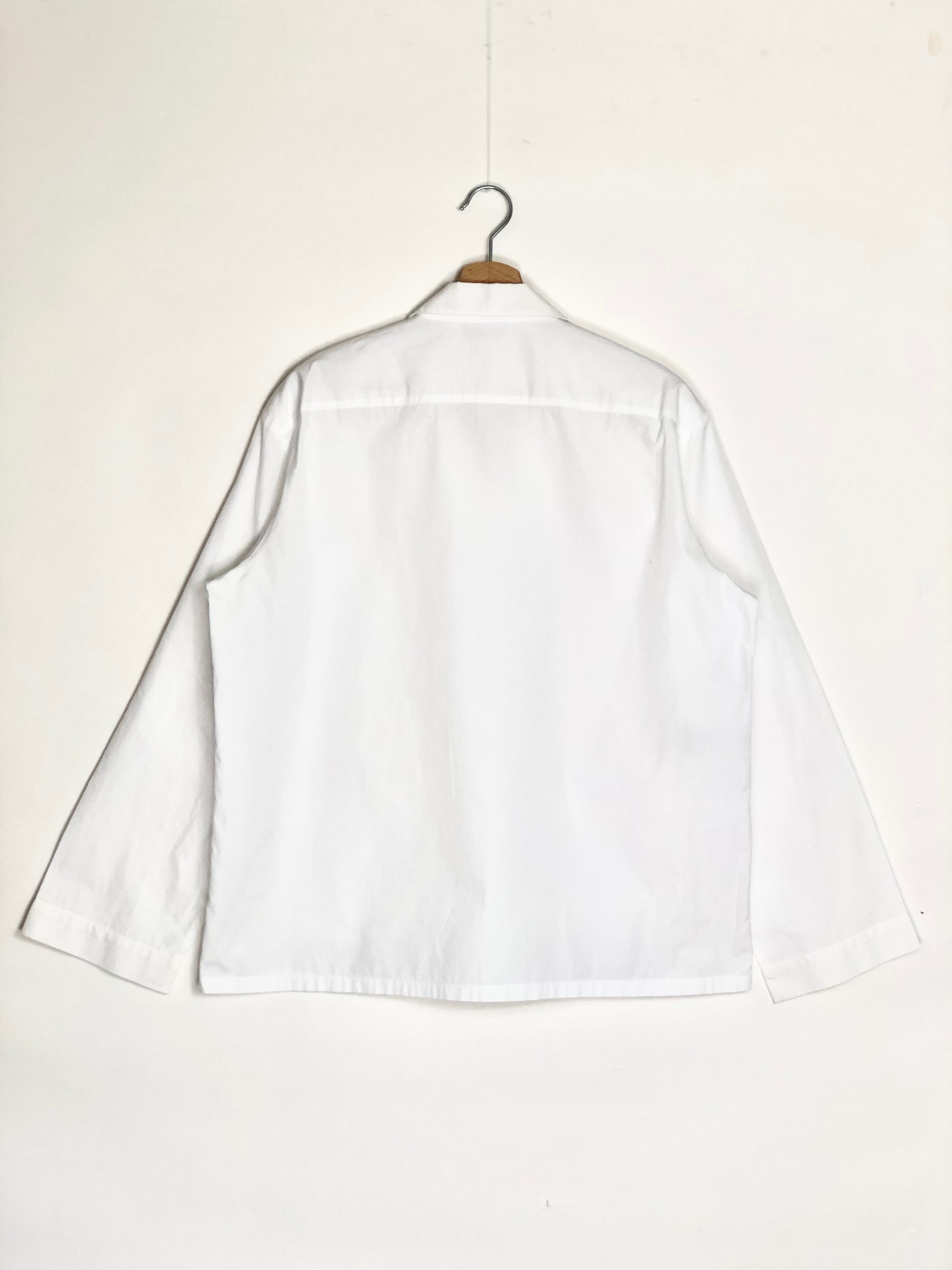 White shirt on a hanger against a white background