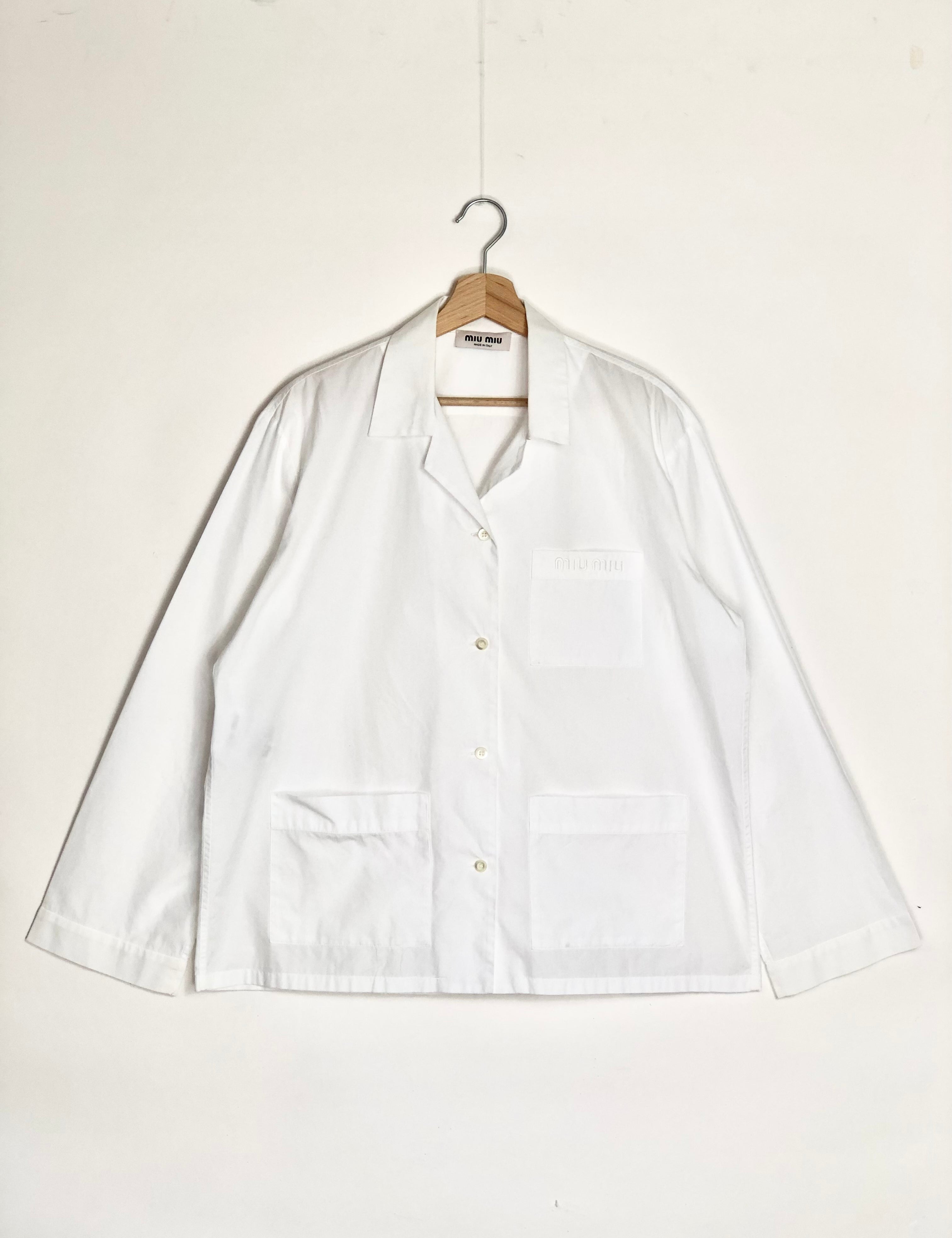 White shirt on a hanger against a white background