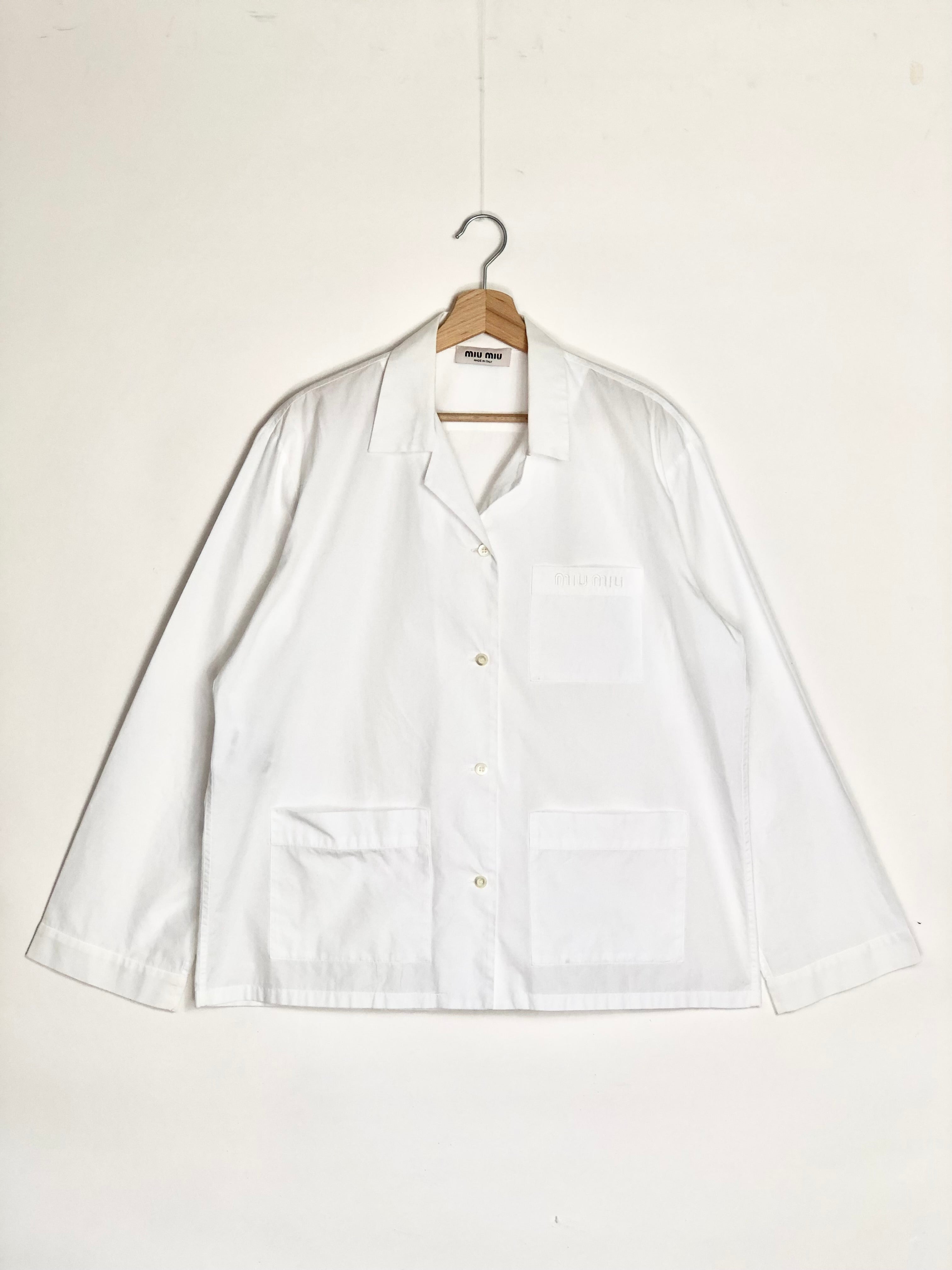 White shirt on a hanger against a white background