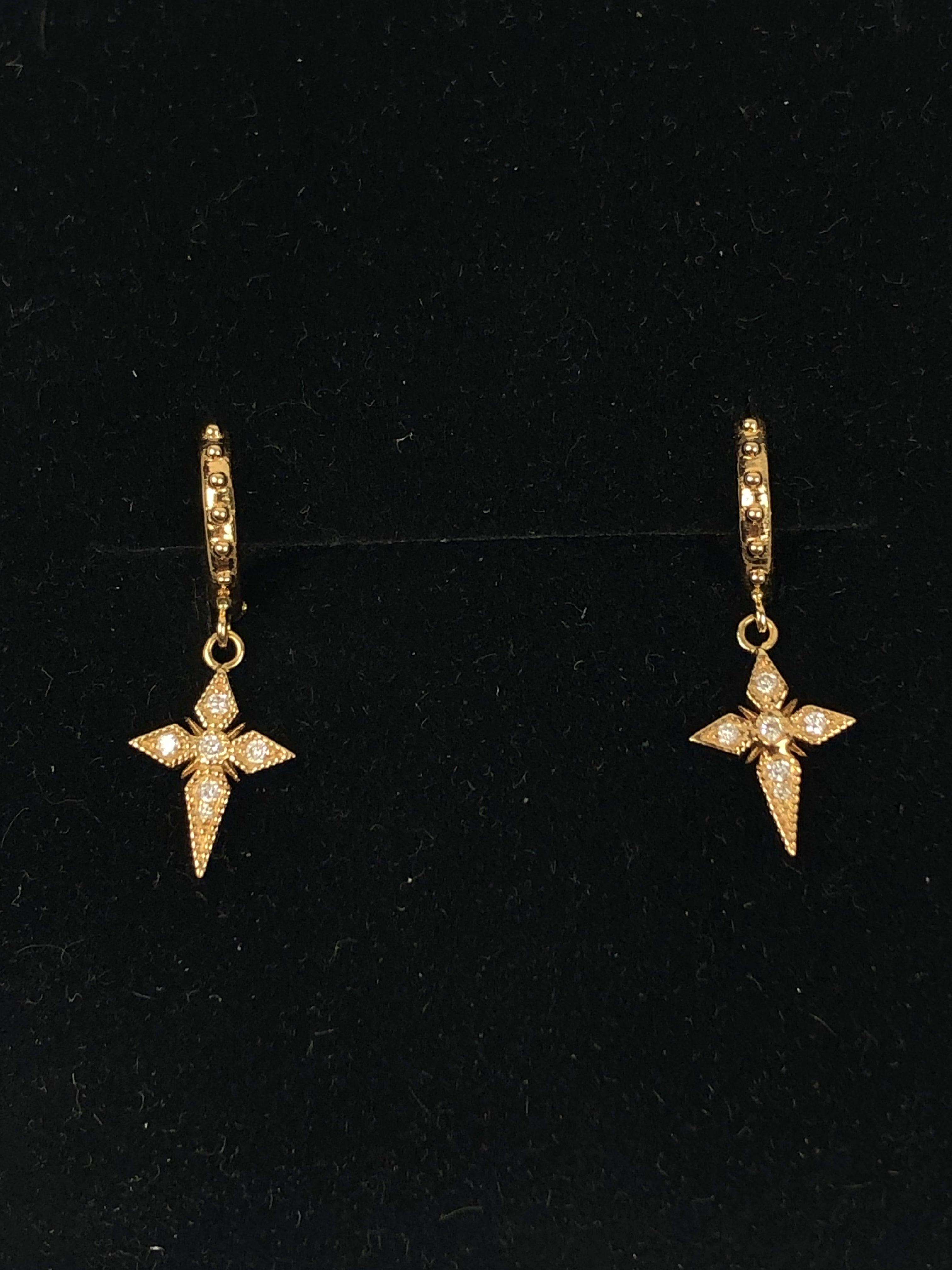Pair of gold star-shaped earrings on a black background