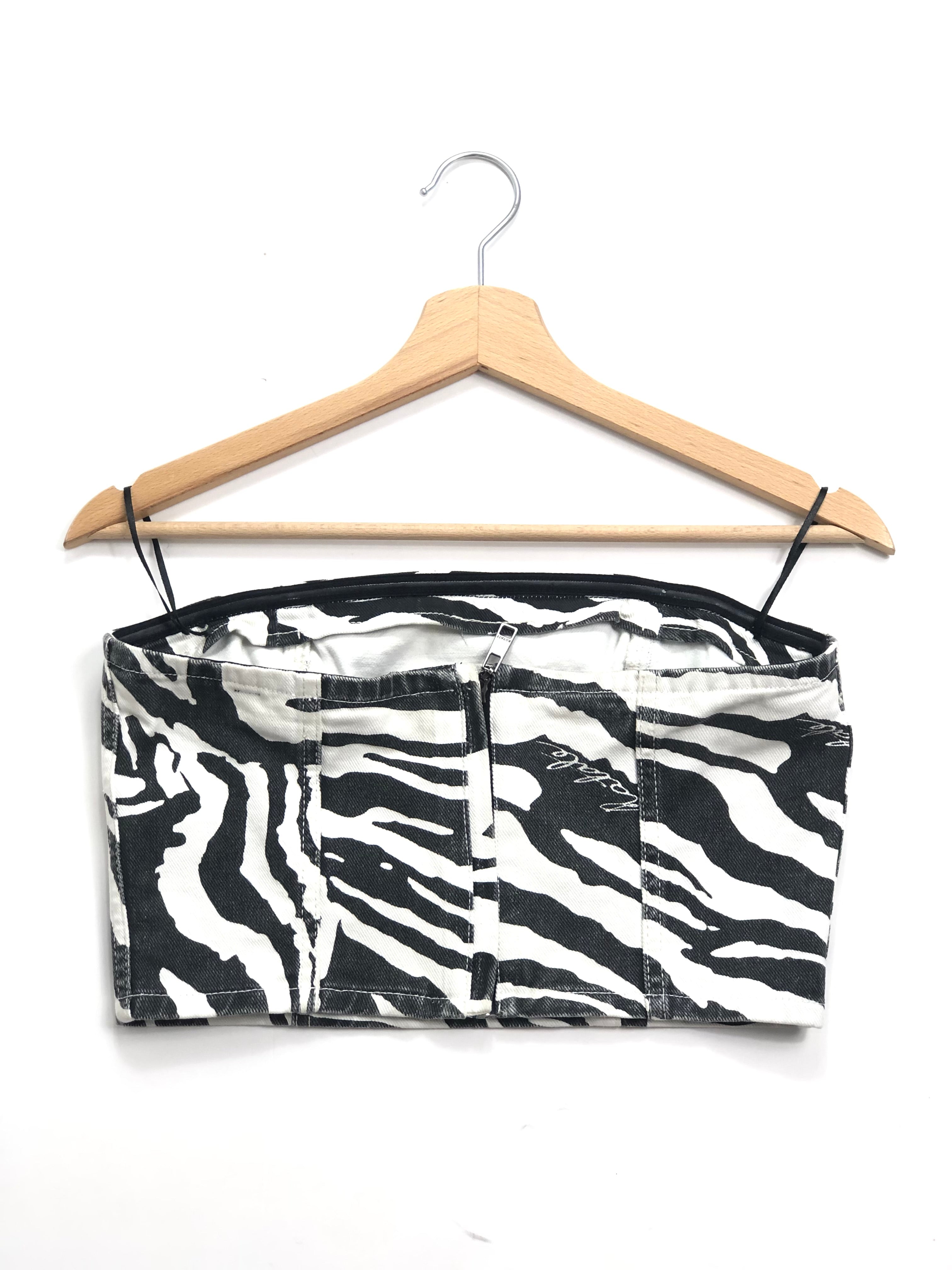 Zebra print strapless top on a wooden hanger against a white background