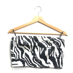 Black and white zebra print top on a wooden hanger against a white background
