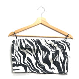 Black and white zebra print top on a wooden hanger against a white background